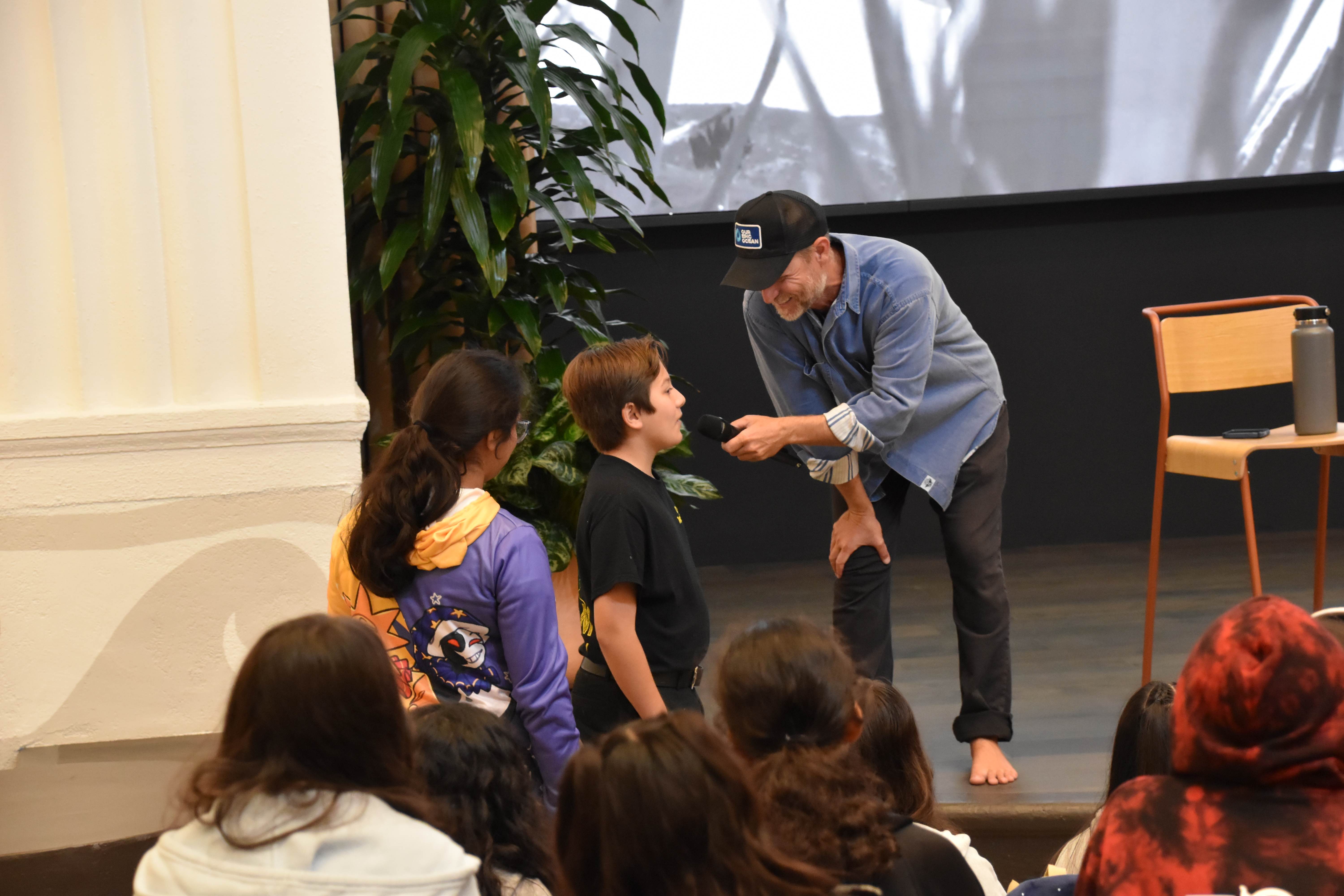 Rich German engaging closely with young students during presentation, intimate educational moment, inspiring youth connection